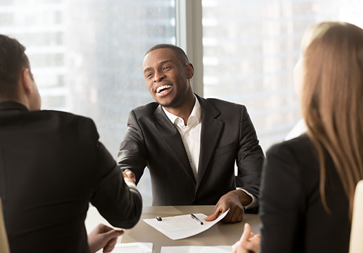 two man shaking hands across a conference table