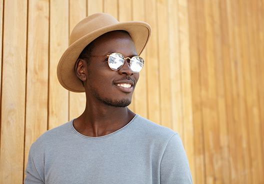 man with hat and sunglasses looking away from the camera