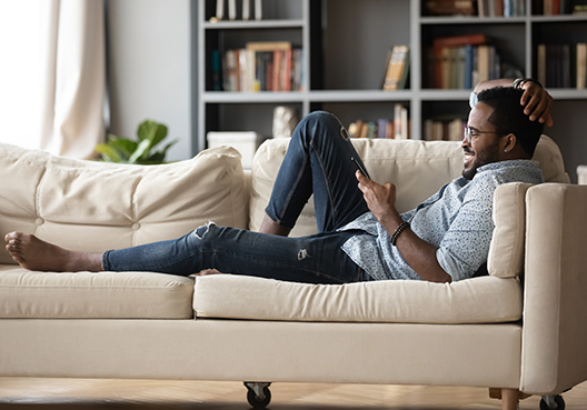 Man relaxing on the couch looking at his phone