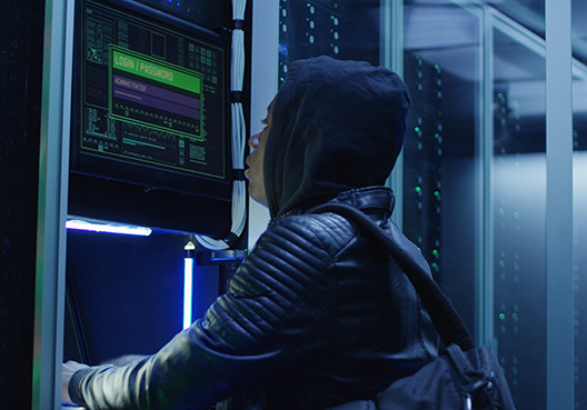 guy working on a computer screen while in a server room