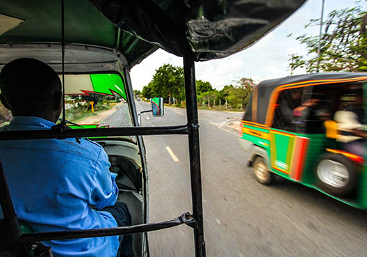 man driving a tuk tuk on the road