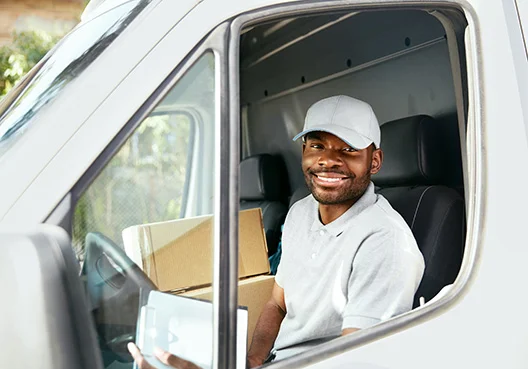man sitting in a truck staring at the camera with a huge smile on his face
